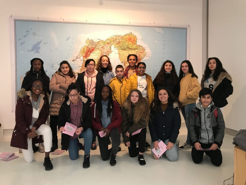 photo de groupe avec les collégiens et Elodie Rama dans la salle d'exposition